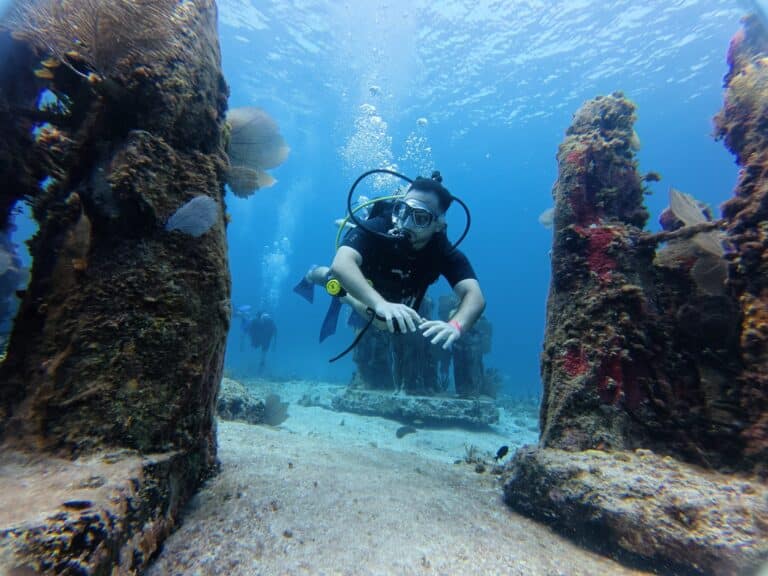 Scuba diving in MUSA Cancun underwater museum with Vision Océanos.