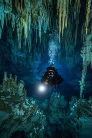 Diver exploring the crystal clear fresh water of a cenote near Cancún with Vision Oceanos